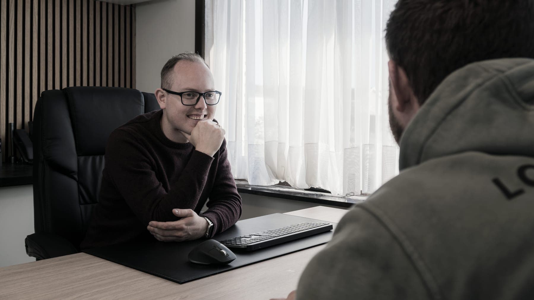 Davy Stevens in gesprek met een medewerker aan zijn bureau